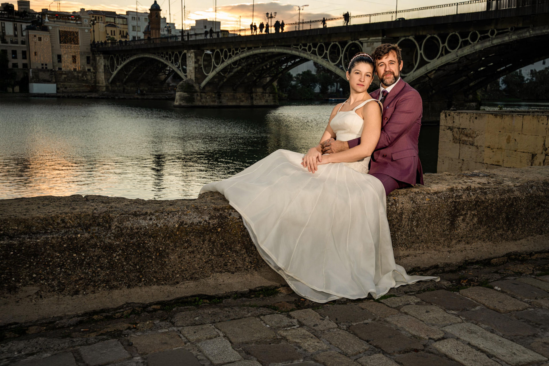 Pareja con Triana al fondo durante el atardecer.