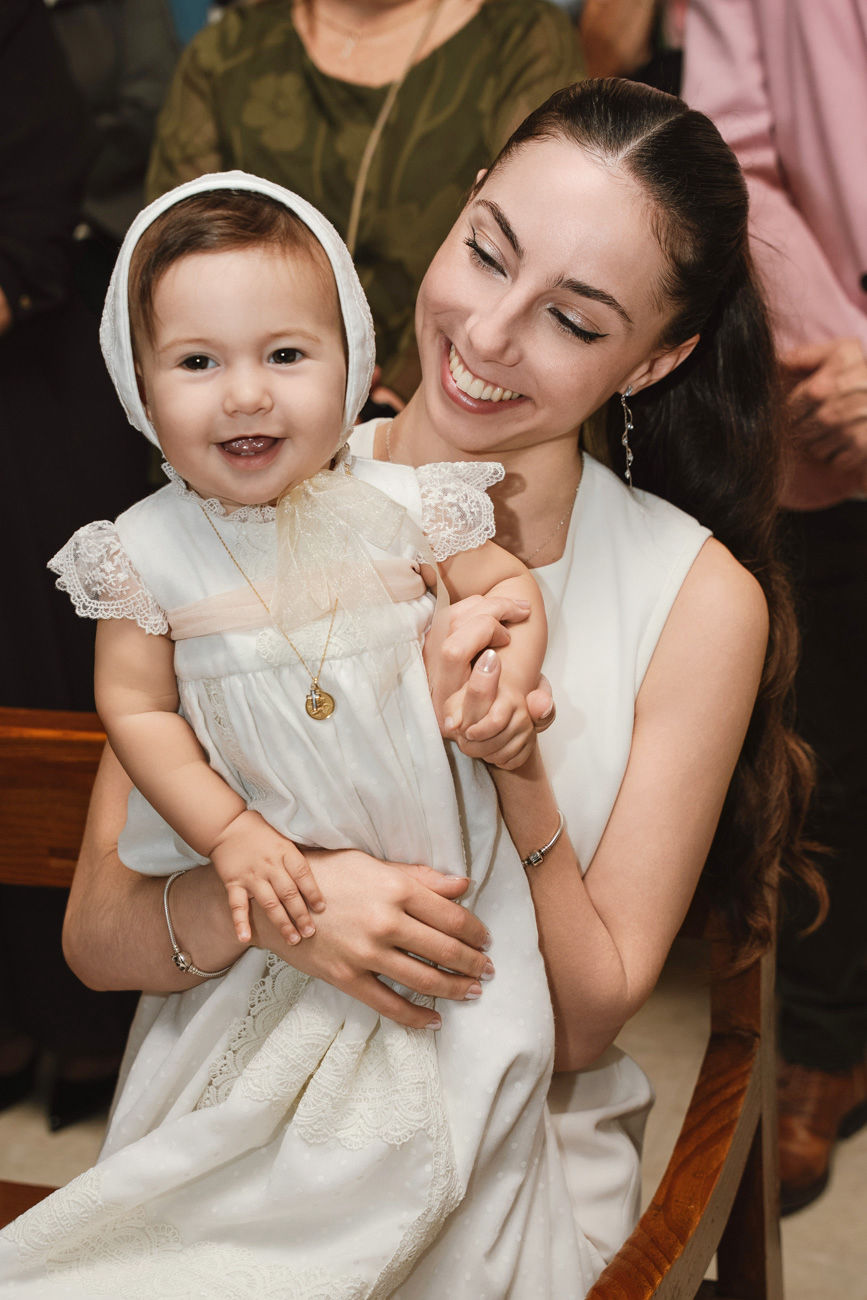 bebé en brazos de la madrina durante su bautizo en la iglesia de san román sevilla fotografía profesional de foto eventos
