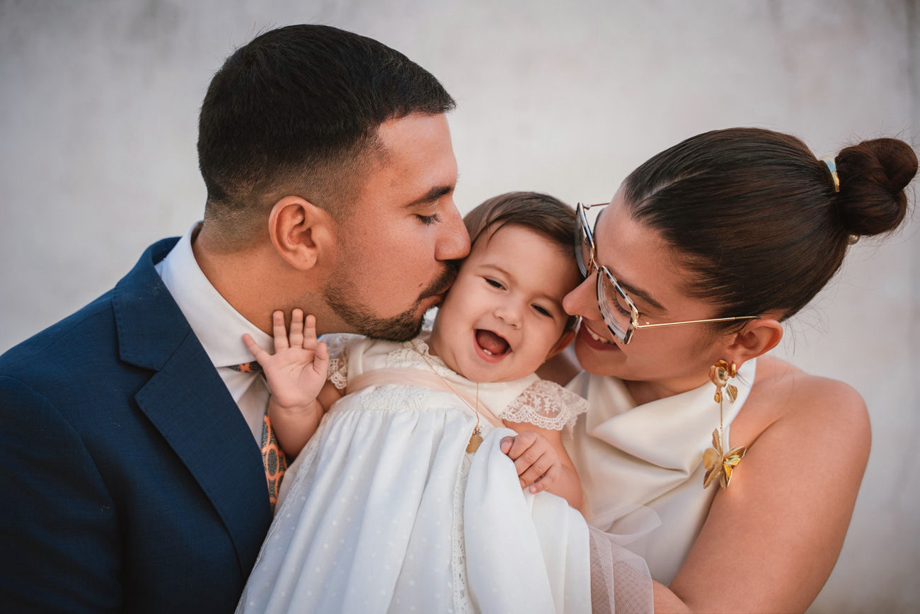 bebé en brazos de la madrina durante su bautizo en la iglesia de san román sevilla fotografía profesional de foto eventos