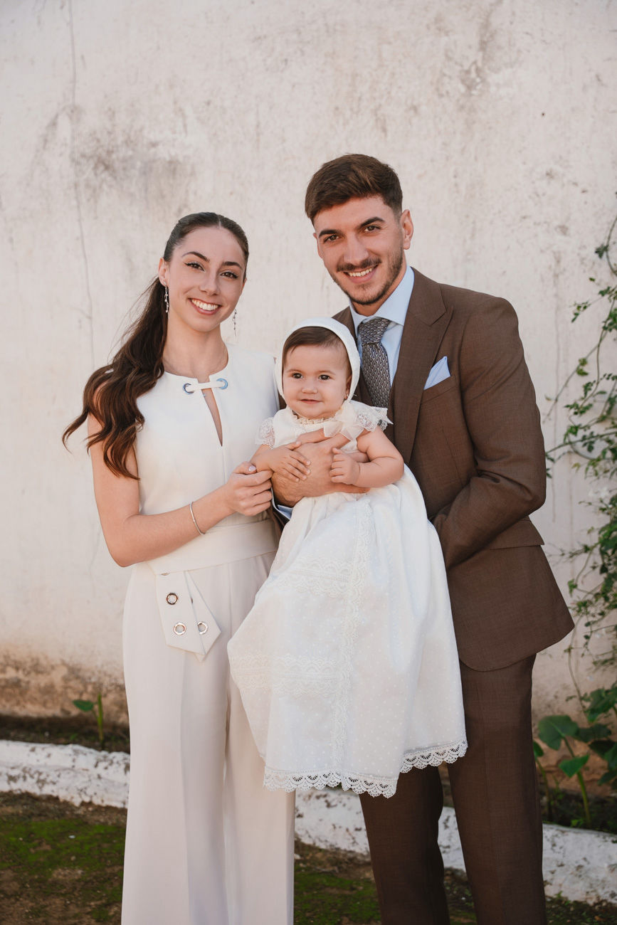 bebé en brazos de la madrina durante su bautizo en la iglesia de san román sevilla fotografía profesional de foto eventos