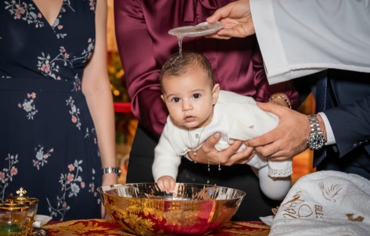 bebé en brazos de la madrina durante su bautizo en la iglesia de san román sevilla fotografía profesional de foto eventos