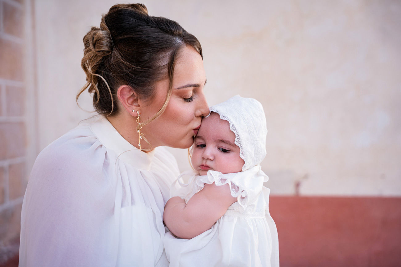 bebé en brazos de la madrina durante su bautizo en la iglesia de san román sevilla fotografía profesional de foto eventos