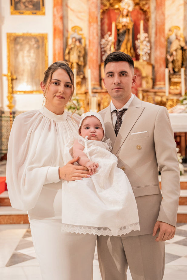 bebé en brazos de la madrina durante su bautizo en la iglesia de san román sevilla fotografía profesional de foto eventos