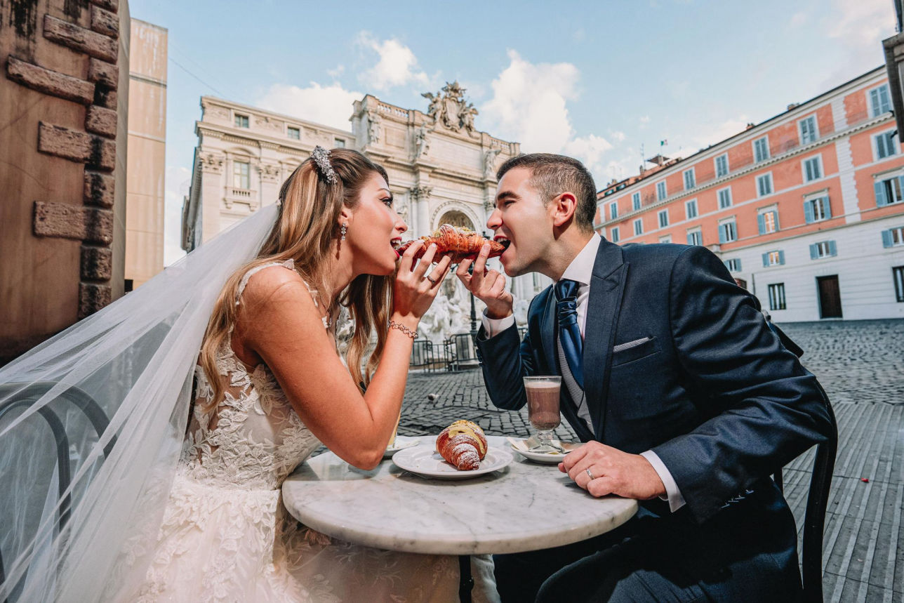 Pareja de novios en la Fontana di Trevi al amanecer durante sesión de postboda en Roma.