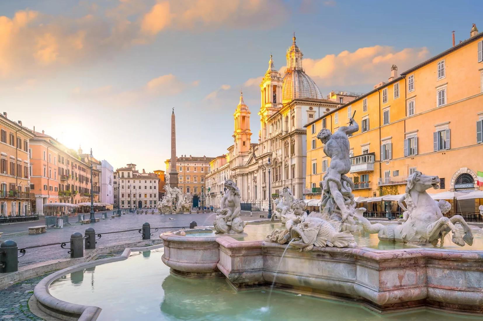 Novios posando en Piazza Navona con la fuente y arquitectura histórica de fondo.
