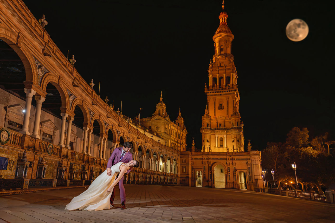 Pareja cruzando uno de los puentes iluminados de Plaza de España.